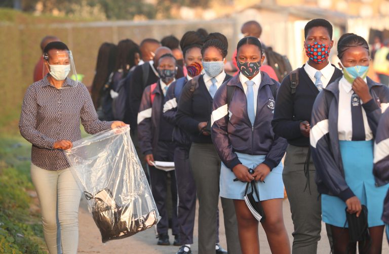South Africa To Vaccinate Teenagers With Single Shot of Pfizer 17 A teacher distributes masks to students as schools begin to reopen after the coronavirus disease (COVID-19) lockdown in Langa township in Cape Town, South Africa June 8, 2020. REUTERS/Mike Hutchings/File Photo